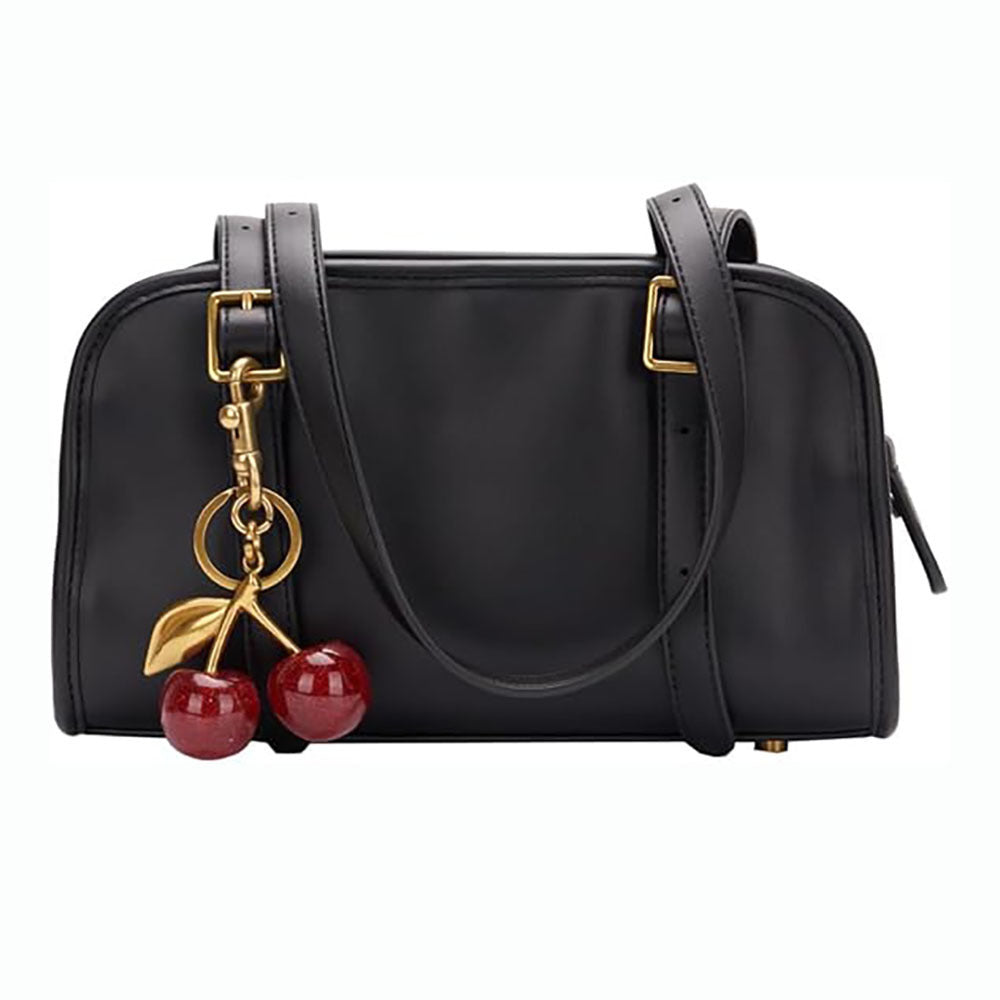 Black handbag with cherry charm on a white background